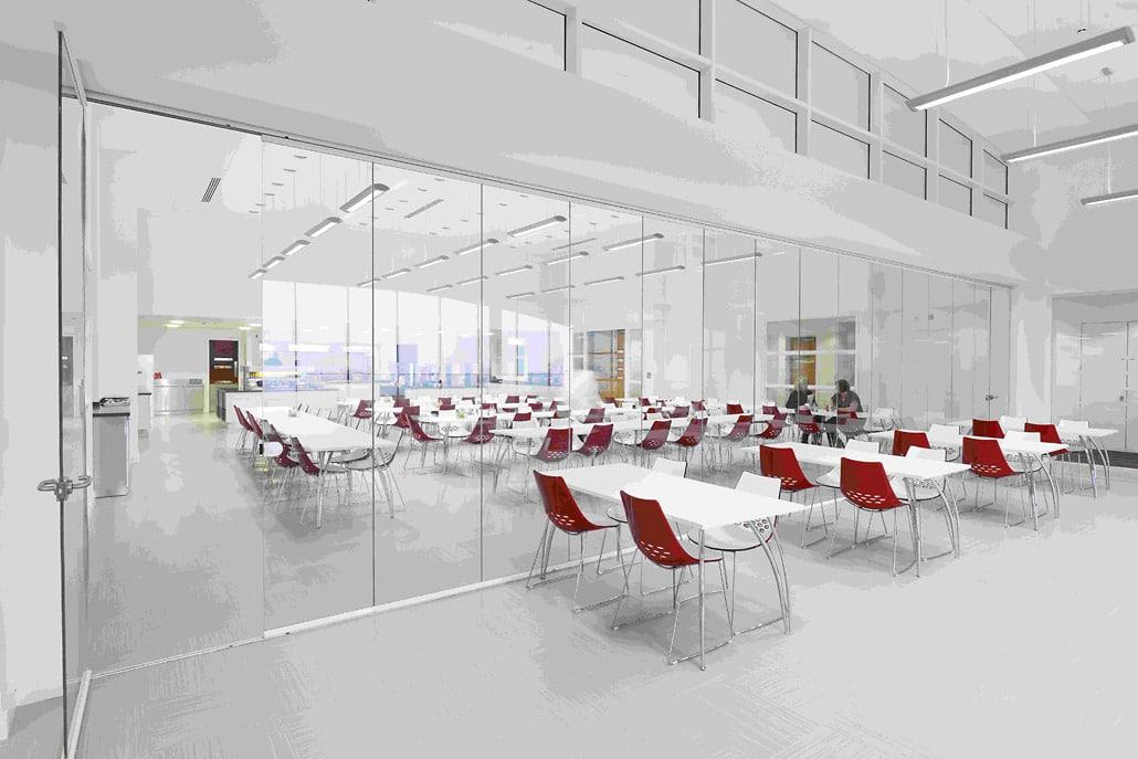 Full-height frameless interior glass doors partitioning a bright office meeting room