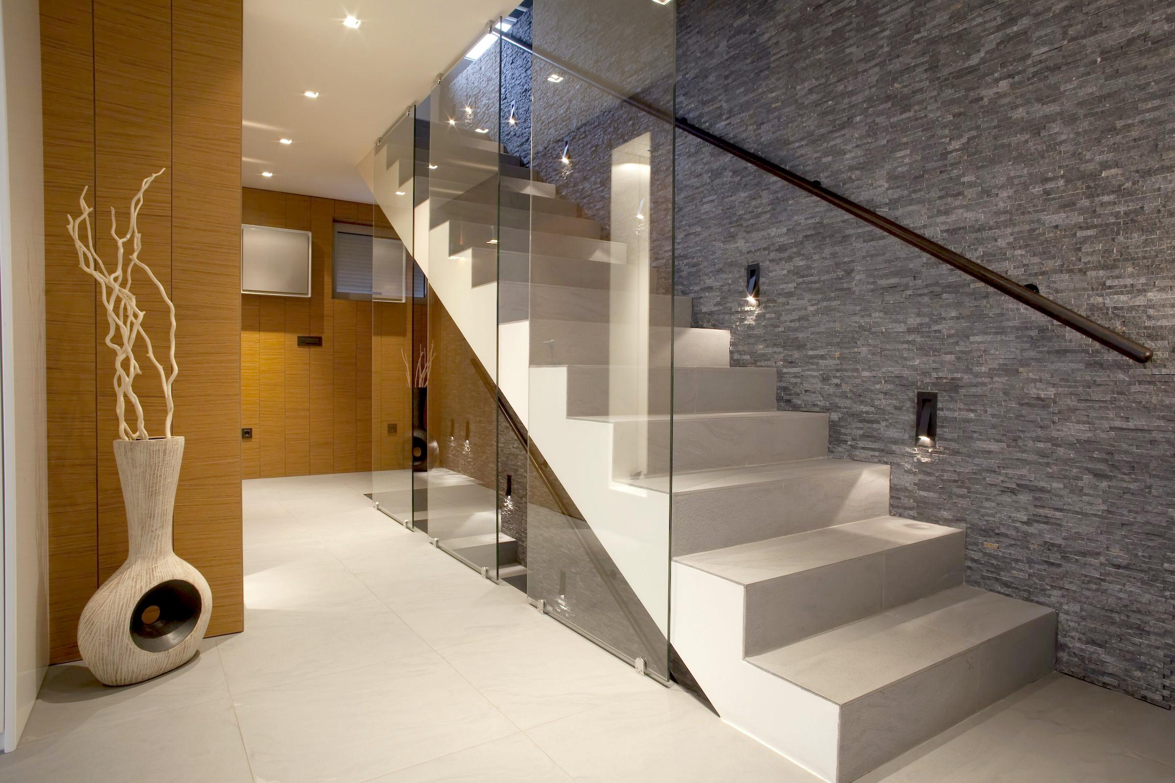Frameless glass balustrades running alongside a timber staircase in a contemporary home interior